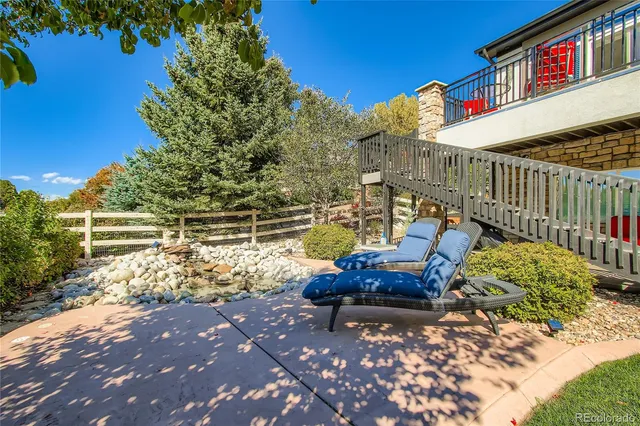 a wooden bench sitting in backside of a house with a yard