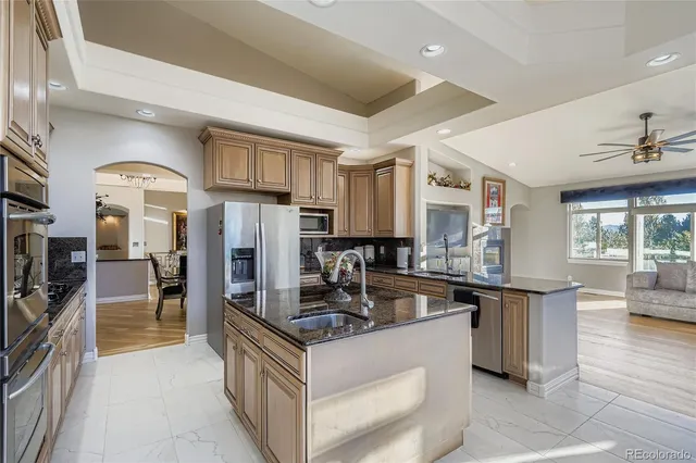 a kitchen with stainless steel appliances granite countertop a sink stove and refrigerator
