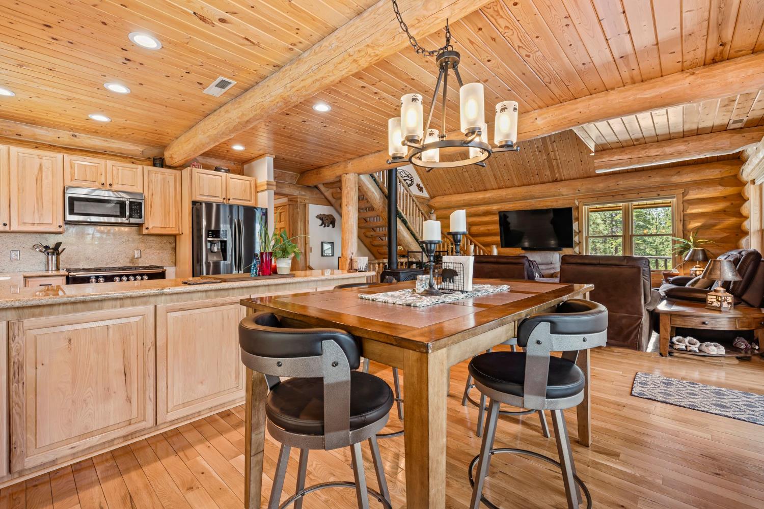 3589 Rocky Point Road South Lake Tahoe, CA 96150 - Photo 9 of 95 a kitchen with stainless steel appliances kitchen island granite countertop a table chairs in it and wooden floors