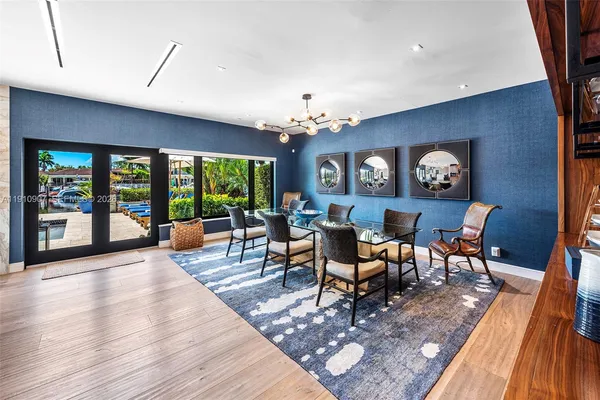 a view of a dining room with furniture a chandelier and wooden floor