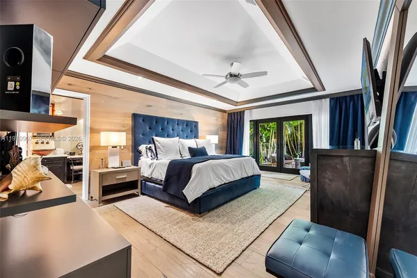 a bedroom with a bed a couch and large window