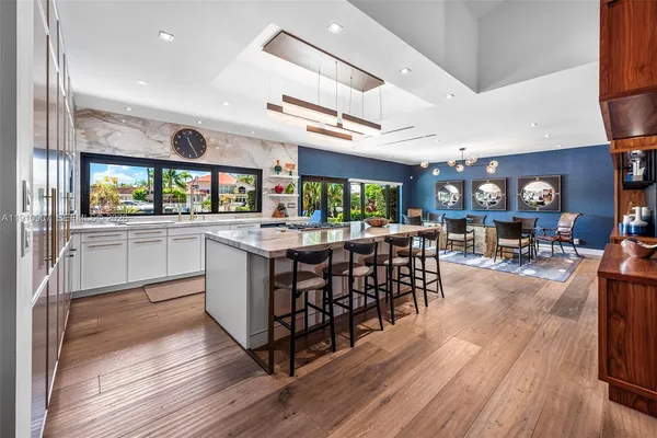 a kitchen with stainless steel appliances a dining table chairs stove and cabinets