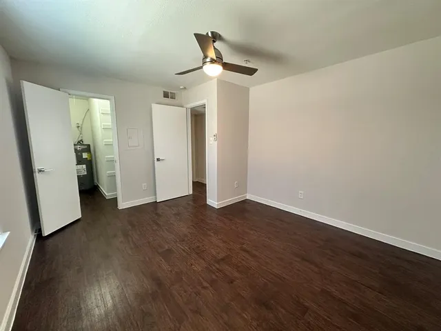 an empty room with wooden floor and white walls