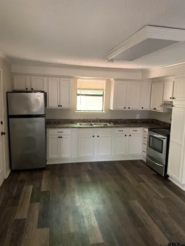 a kitchen with wooden floors and white appliances
