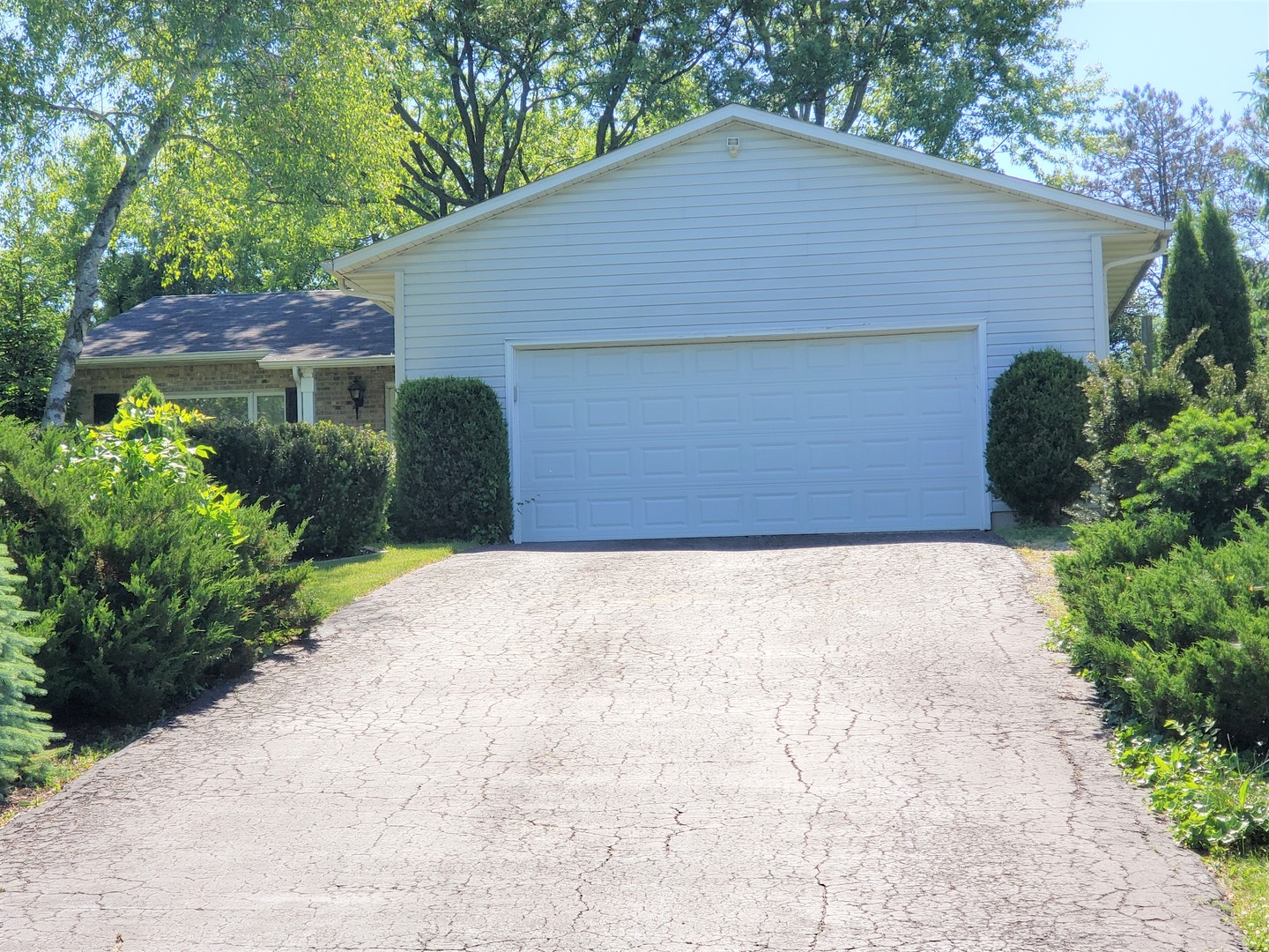 a front view of house with yard and trees around