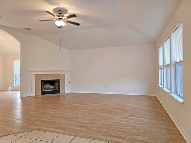 a view of an empty room with a fireplace and a window