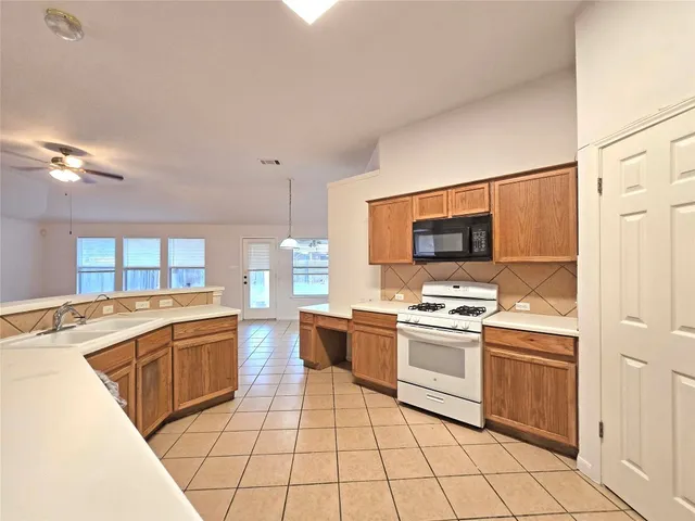 a kitchen with stainless steel appliances granite countertop a stove a sink and a refrigerator