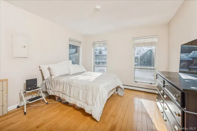 a bedroom with a bed and a flat tv screen on the dresser