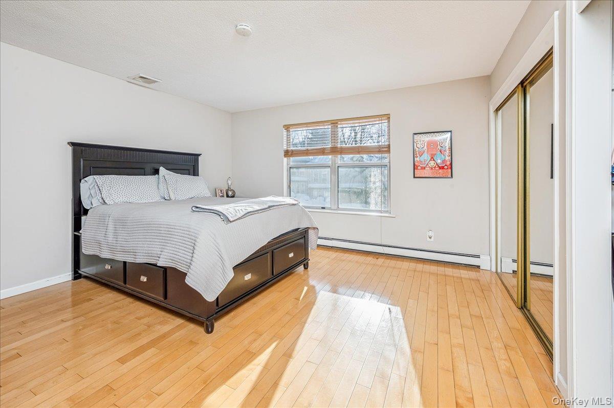 58 Villa Drive Peekskill, NY 10566 - Photo 15 of 21 Master Bedroom featuring a closet, light wood-style floors, and a baseboard heating unit