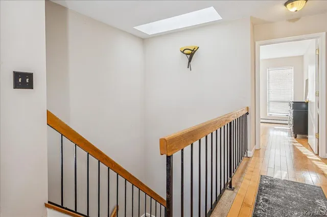 a view of a hallway with wooden floor and staircase