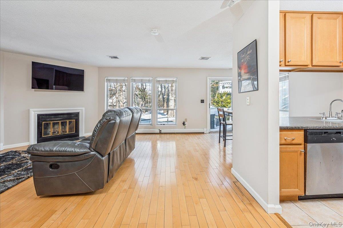 58 Villa Drive Peekskill, NY 10566 - Photo 6 of 21 Living room with light wood-type flooring, a glass covered fireplace, and a textured ceiling