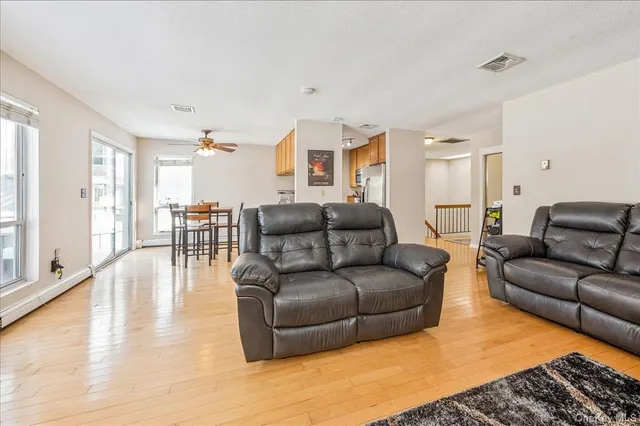 a living room with furniture and a dining table with wooden floor
