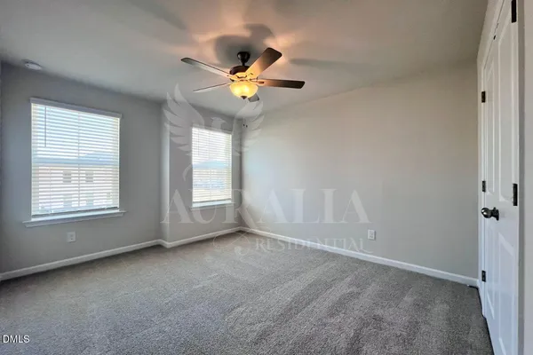 an empty room with closet and a ceiling fan
