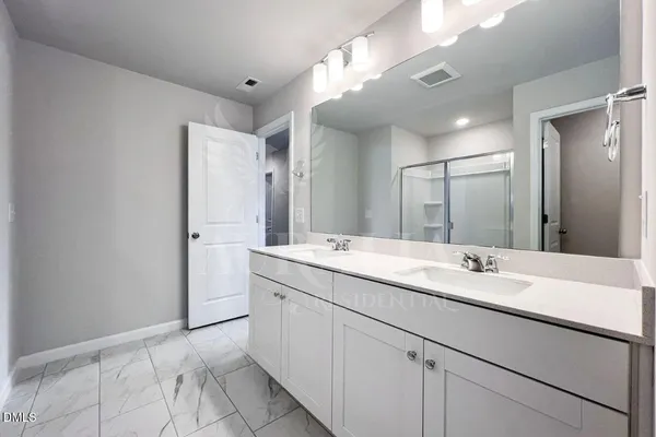 a bathroom with a shower sink and mirror