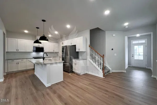 a kitchen with stainless steel appliances a refrigerator and a stove top oven