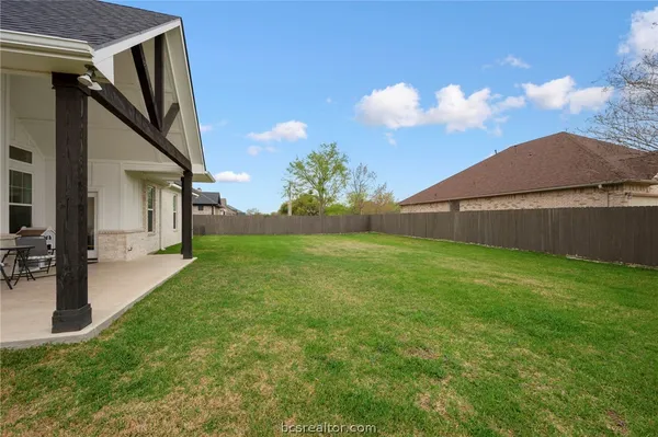 a view of a house with backyard and a tree