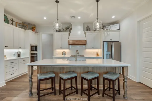 a kitchen with stainless steel appliances granite countertop a sink a stove a refrigerator and island