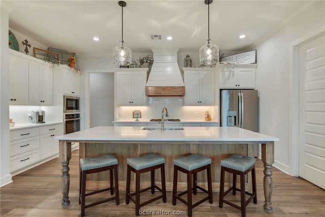 4357 Fox River Lane Bryan, TX 77802 - Photo 4 of 24 a kitchen with stainless steel appliances granite countertop a sink a stove a refrigerator and island