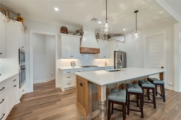 a kitchen with a table chairs refrigerator and microwave