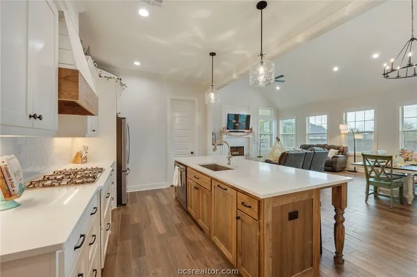 a kitchen with kitchen island a sink stove and wooden floor
