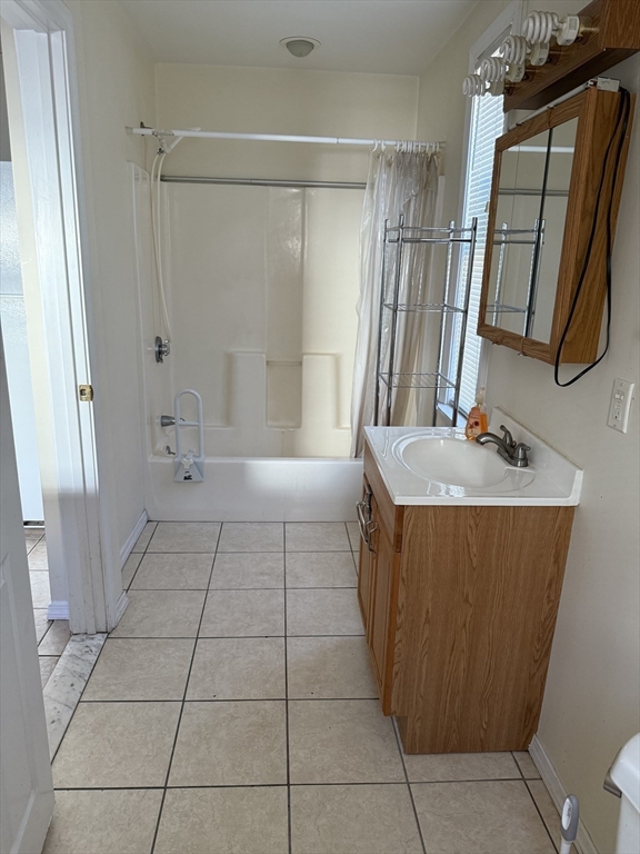 66 Cottage Street, Unit 1 Everett, MA 02149 - Photo 5 of 9 a bathroom with a sink a toilet a mirror and shower