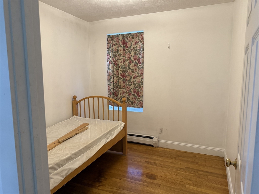 66 Cottage Street, Unit 1 Everett, MA 02149 - Photo 6 of 9 a bedroom with a bed and wooden floor