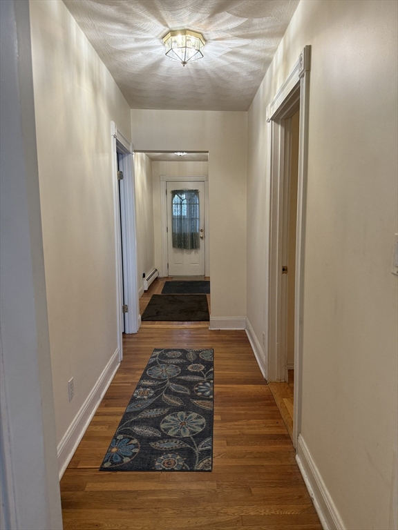 66 Cottage Street, Unit 1 Everett, MA 02149 - Photo 8 of 9 a view of a hallway with wooden floor and staircase