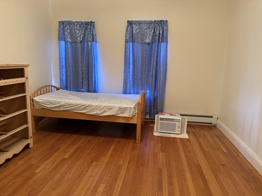 66 Cottage Street, Unit 1 Everett, MA 02149 - Photo 9 of 9 a bedroom with a bed and wooden floor