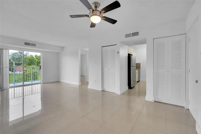 a view of a livingroom with a ceiling fan and window