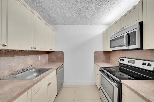 a kitchen with a sink stove and microwave