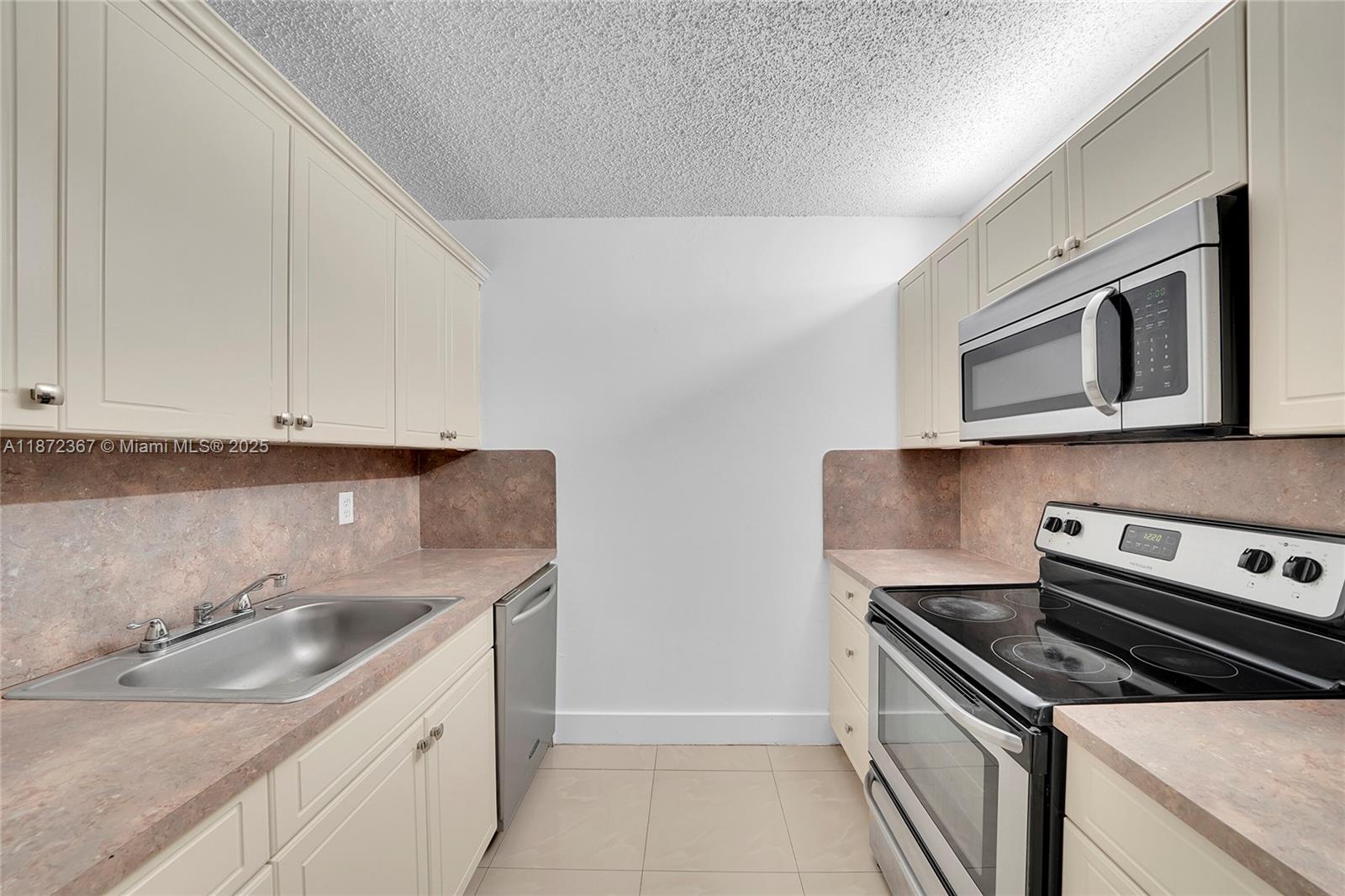 8260 Southwest 210th Street, Unit 201 Cutler Bay, FL 33189 - Photo 11 of 33 a kitchen with a sink stove and microwave