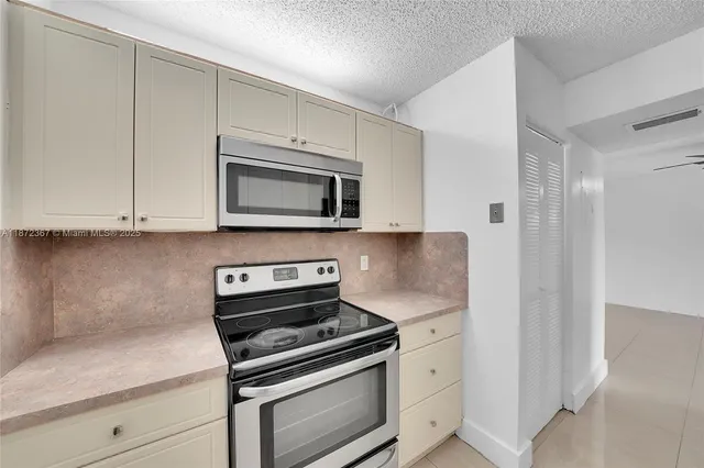 a kitchen with stainless steel appliances white cabinets and stove top oven