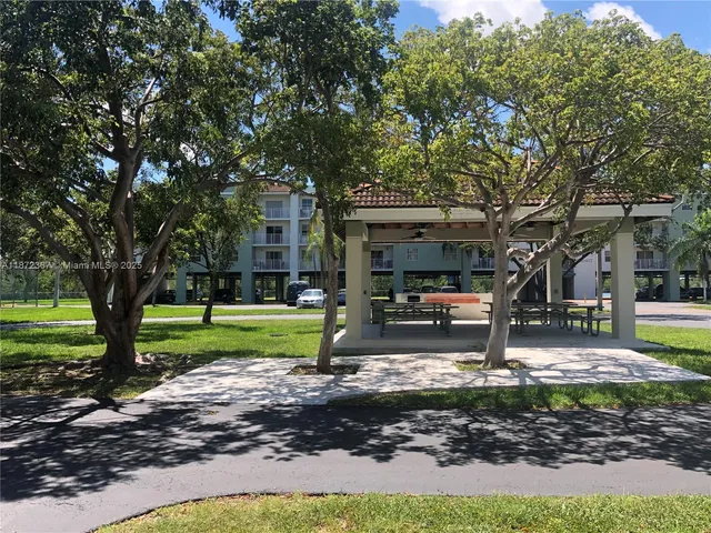 a view of a park that has a tree on the side of the road