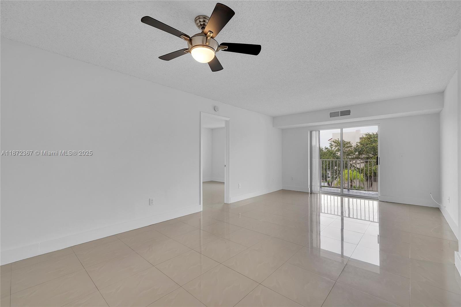 8260 Southwest 210th Street, Unit 201 Cutler Bay, FL 33189 - Photo 3 of 33 an empty room with windows and ceiling fan