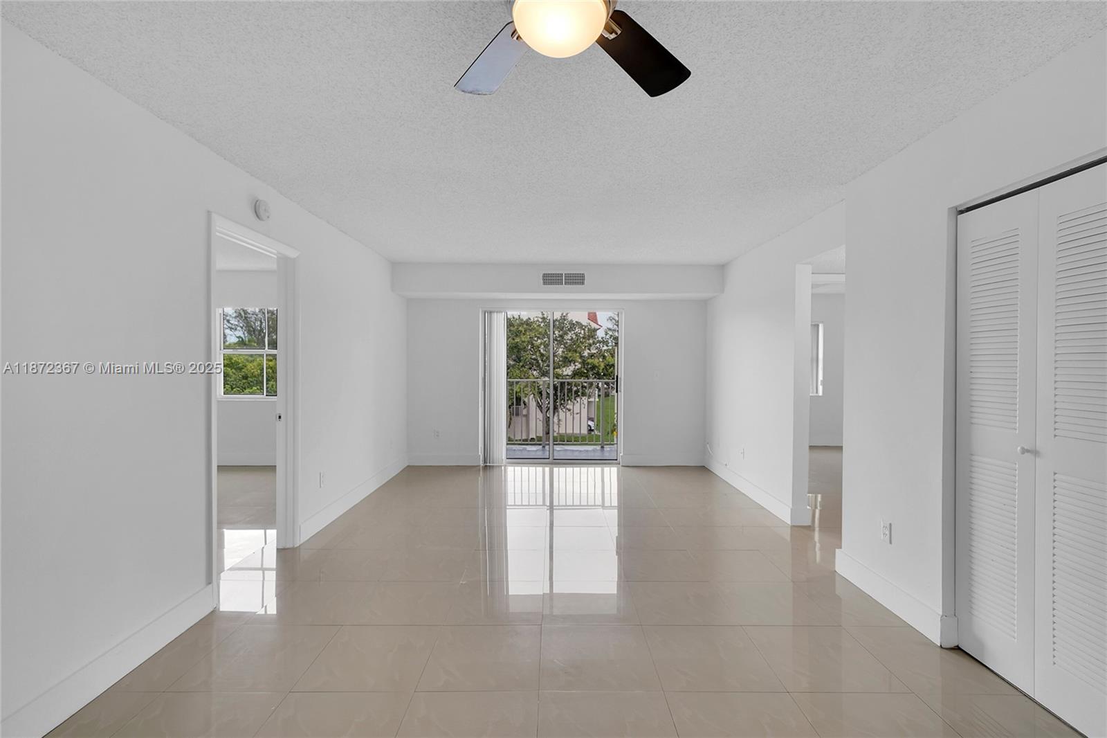 8260 Southwest 210th Street, Unit 201 Cutler Bay, FL 33189 - Photo 4 of 33 an empty room with chandelier fan and windows
