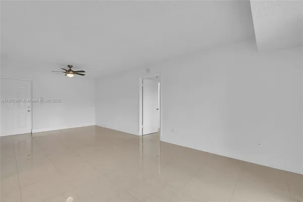 an empty room with a ceiling fan and window