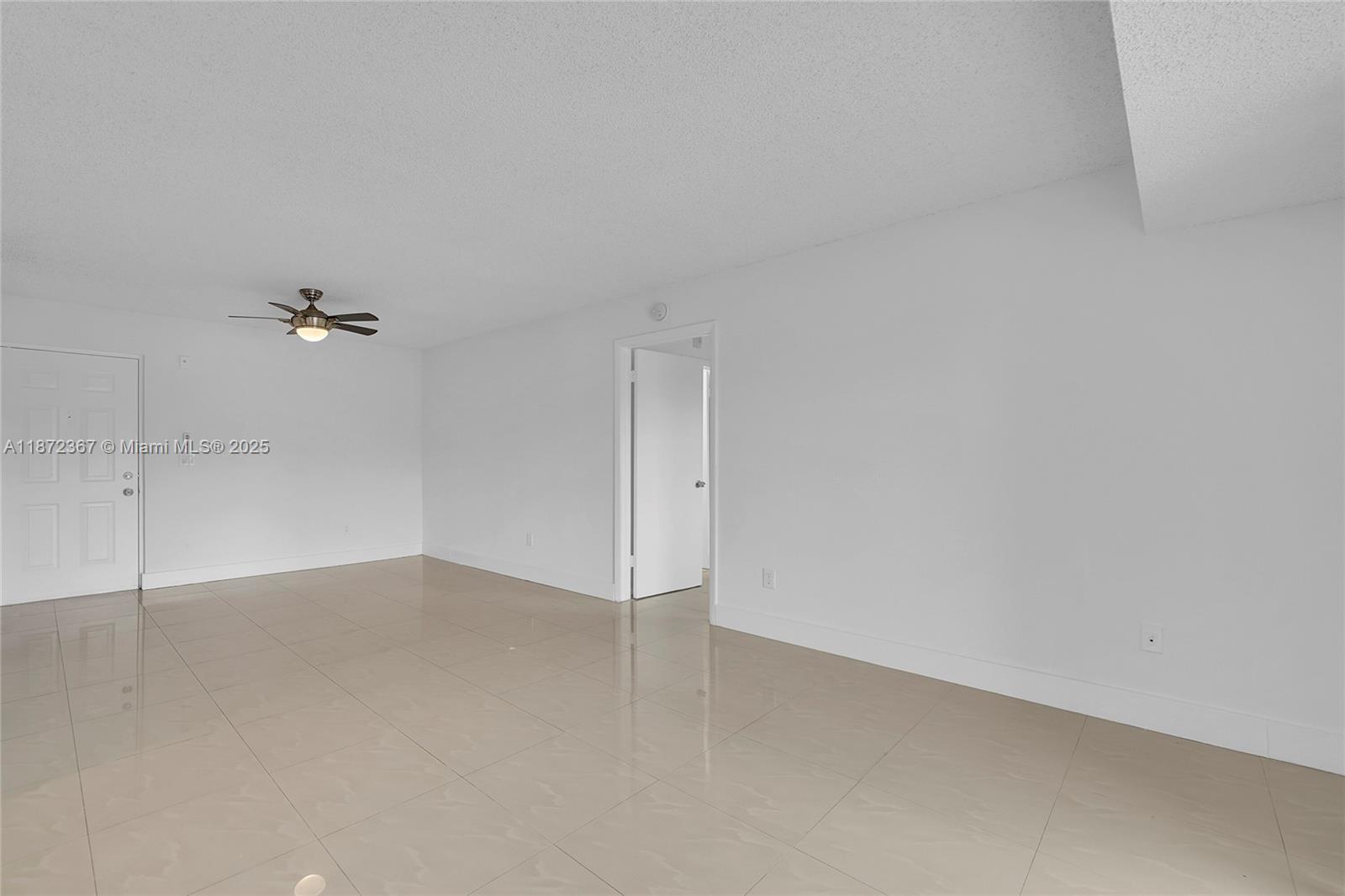 8260 Southwest 210th Street, Unit 201 Cutler Bay, FL 33189 - Photo 8 of 33 an empty room with a ceiling fan and window