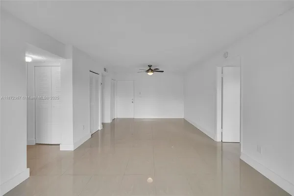an empty room with an entryway and fan