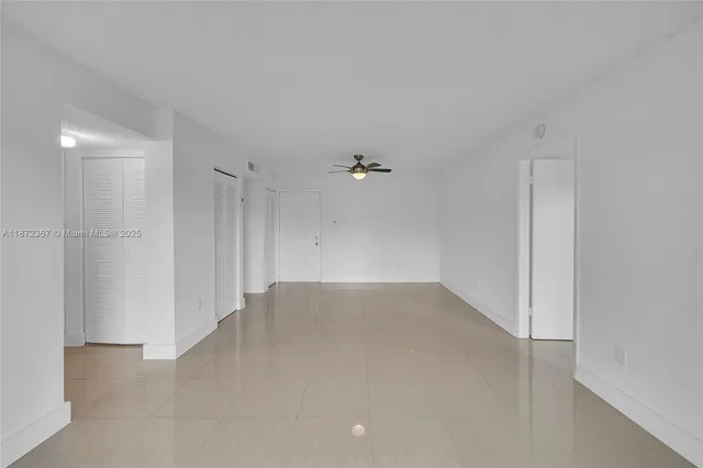 an empty room with an entryway and fan