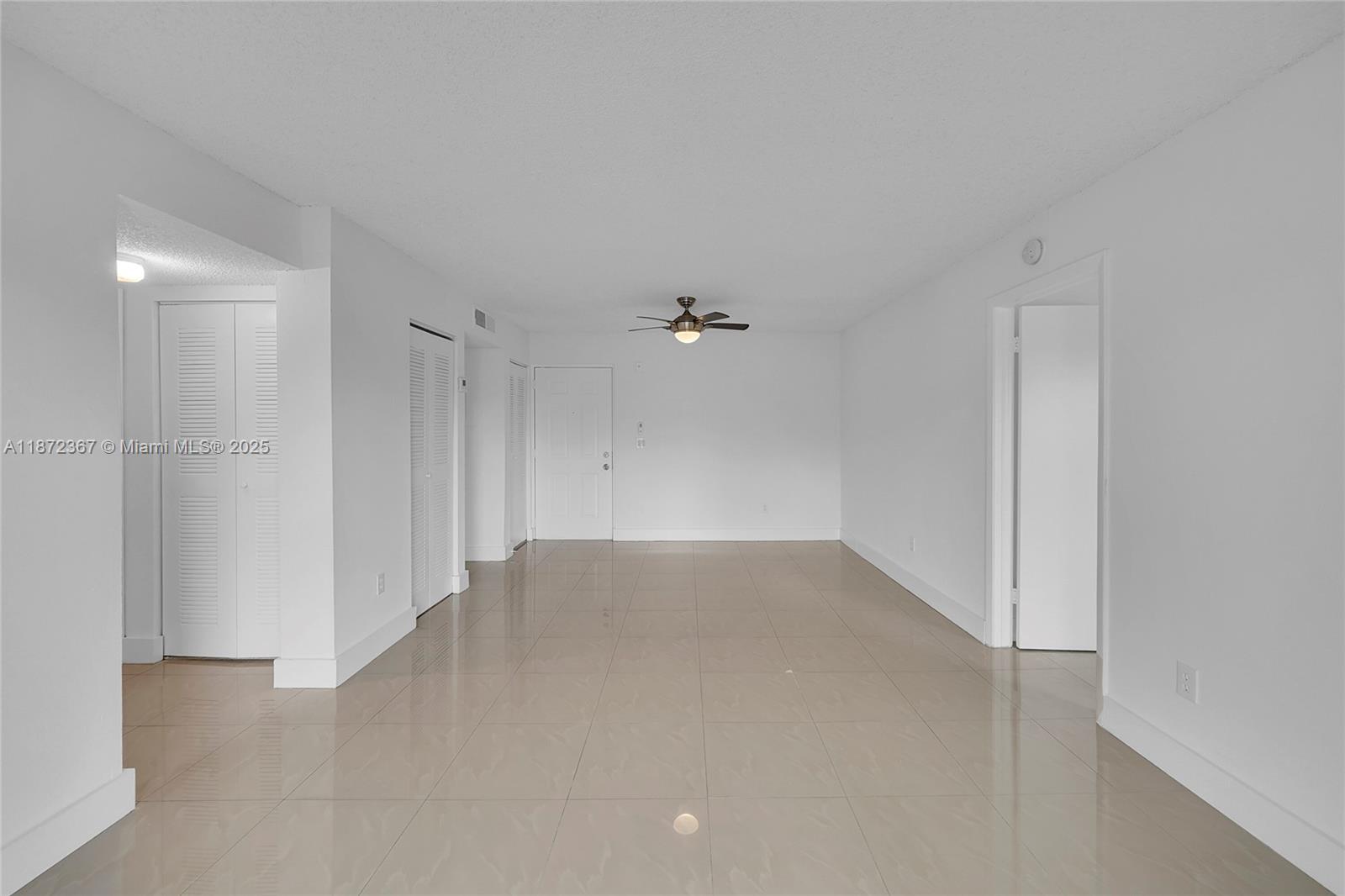 8260 Southwest 210th Street, Unit 201 Cutler Bay, FL 33189 - Photo 9 of 33 an empty room with an entryway and fan