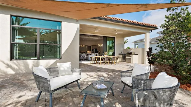 a view of a patio with couches table and chairs and potted plants