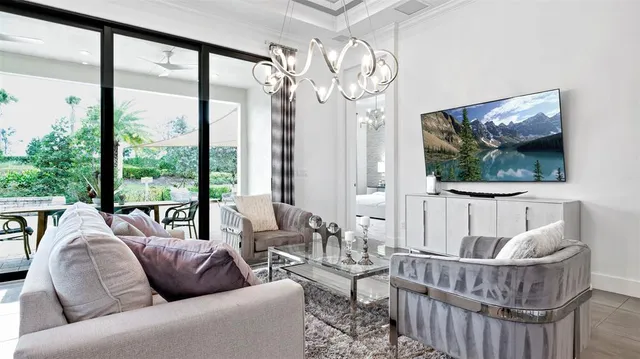 a living room with furniture a large window and a chandelier