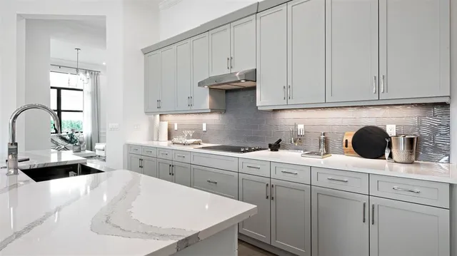 a kitchen with white cabinets a sink and dishwasher