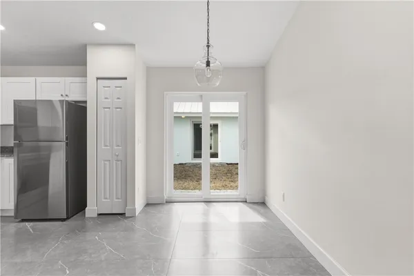 a view of an empty room with a kitchen