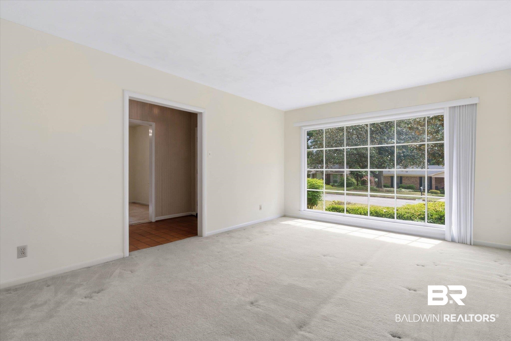 1182 Ginger Drive Mobile, AL 36693 - Photo 5 of 37 Spacious room featuring a large divided-light window, light-toned carpeting, and a broad entryway
