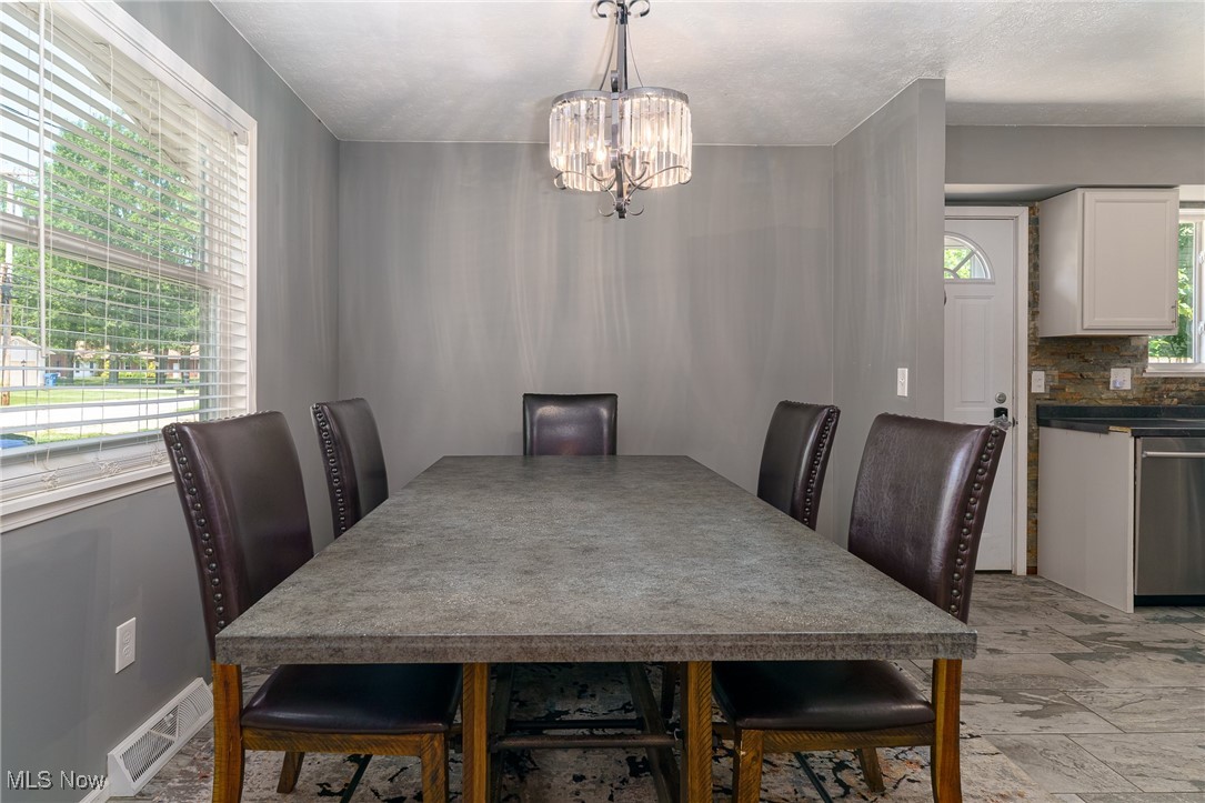 5497 Lear Nagle Road North Ridgeville, OH 44039 - Photo 12 of 33 Dining room with crystal and nickel chandelier. Table and chairs with area rug and large picture window with blinds