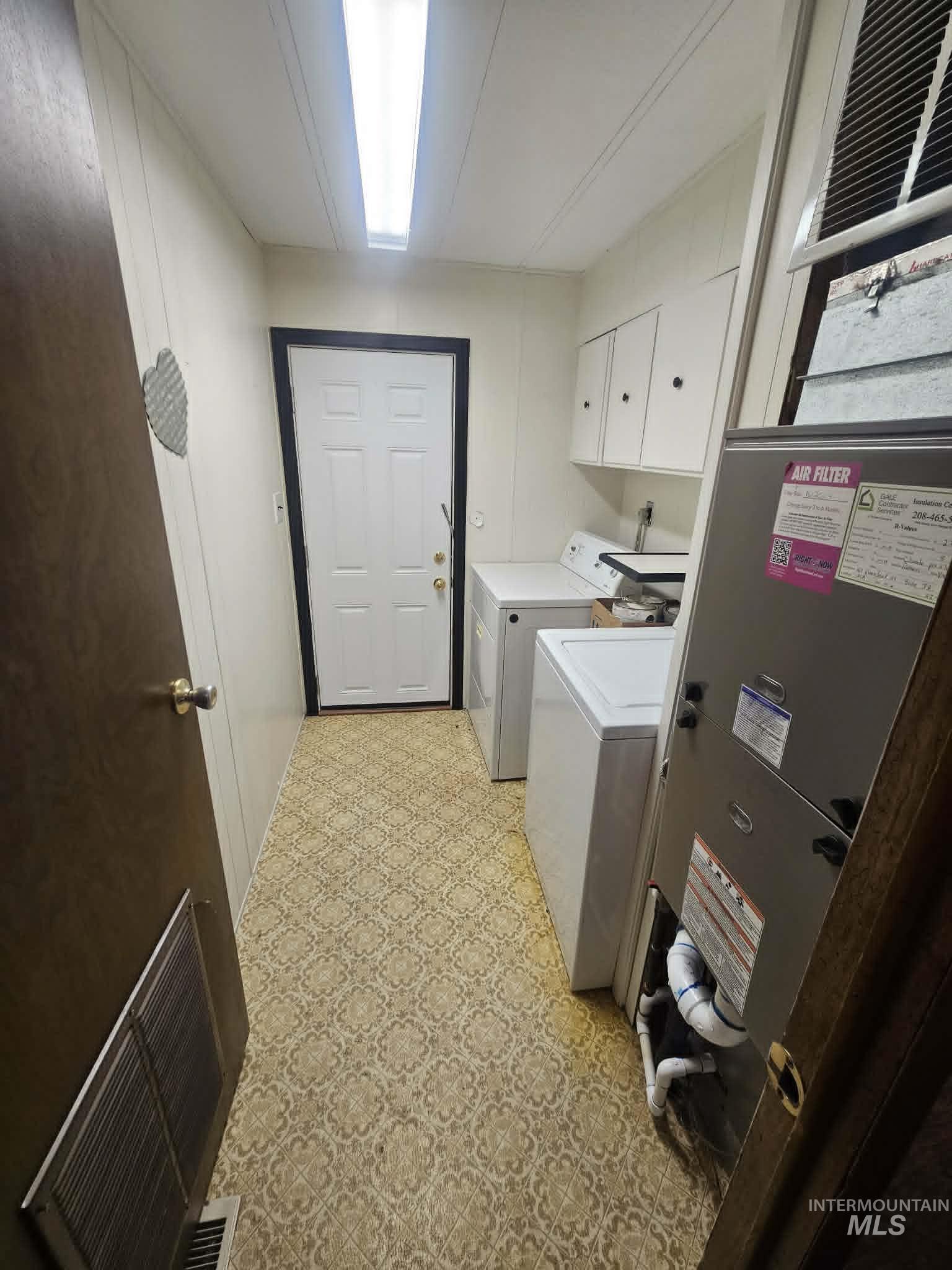 461 Greenleaf Street Boise, ID 83713 - Photo 8 of 19 Dedicated utility room featuring patterned vinyl flooring, white wall paneling, and an exterior access door