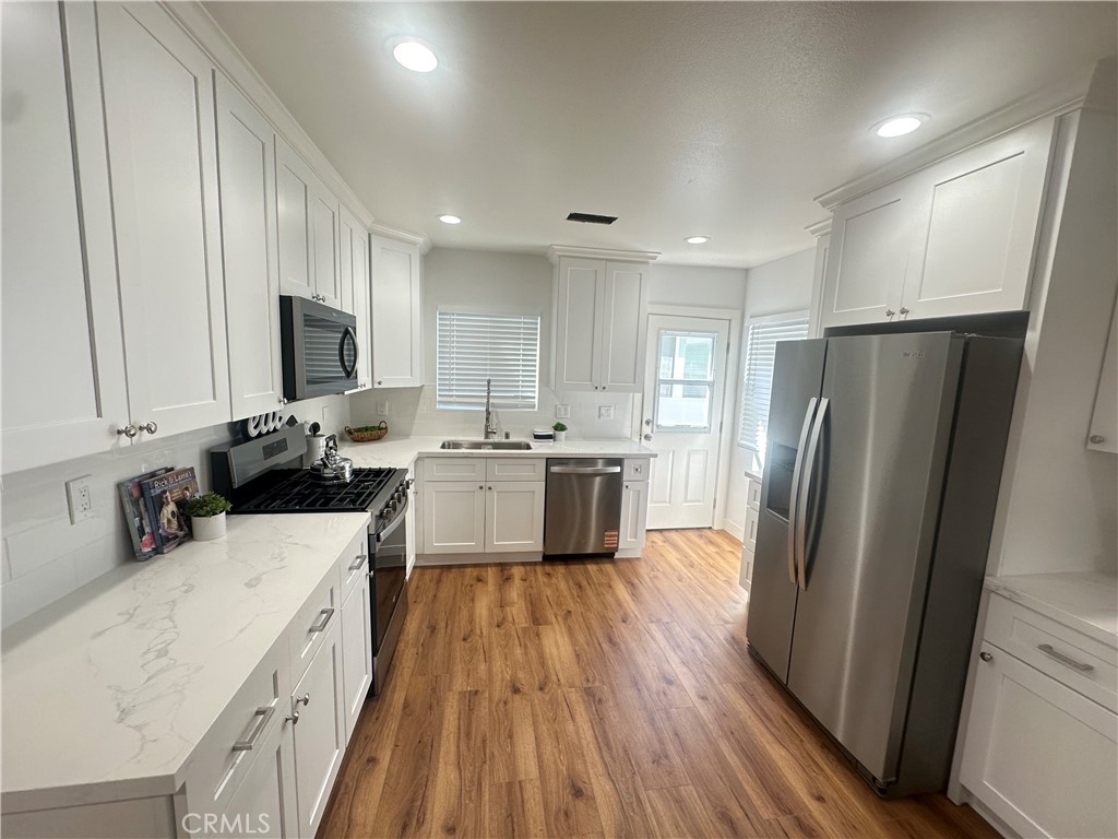 12158 Oracle Street Norwalk, CA 90650 - Photo 5 of 22 a kitchen with a refrigerator a sink and a stove top oven
