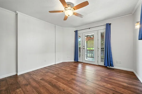 an empty room with wooden floor and windows