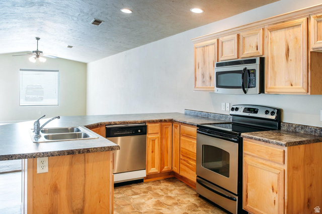 1330 North Dixie Downs Road, Unit 72 St. George, UT 84770 - Photo 6 of 21 Kitchen featuring stainless steel appliances, a peninsula, dark countertops, and a ceiling fan